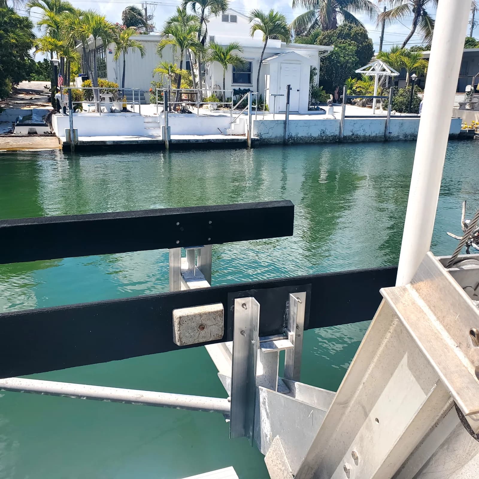 Black boat lift bunks on metal supports above a canal